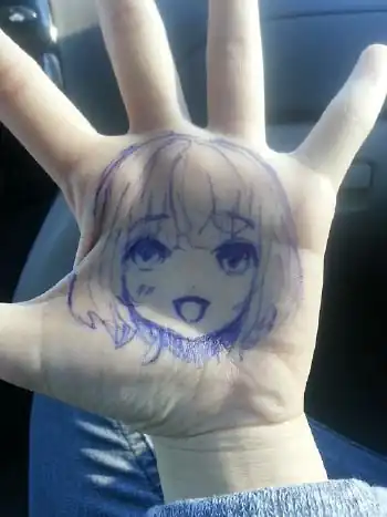 a photo of a hand with the face of a girl drawn on the palm